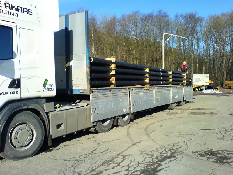 Trailer lastad med rör, sedd från sidan