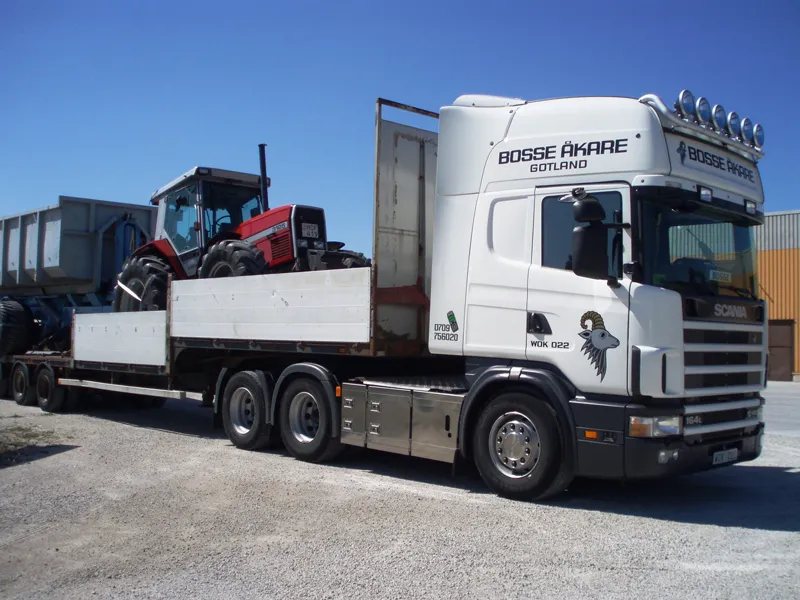 Bosse Åkares Scania med en röd traktor på flaket