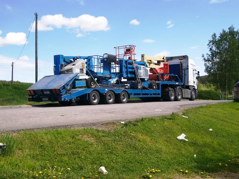 Lågbäddstrailer lastad med liftar, sedd bakifrån