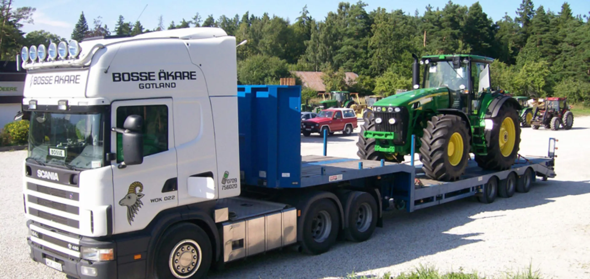 Bosse Åkares Scania med en grön traktor på lågbäddstrailern